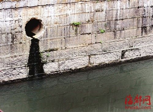 內河一處排污口，正在流出墨黑色污水。