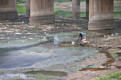 5月27日，一位村民正被嚴(yán)重污染的南沙河河道里打水準(zhǔn)備澆菜，其下游不遠(yuǎn)處，即是沙河水庫。新京報記者 周崗峰 攝